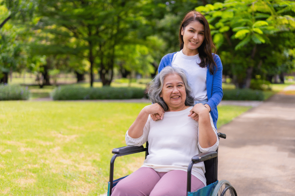 A home care worker helping an elderly woman to take a stroll outdoor in a wheelchair.