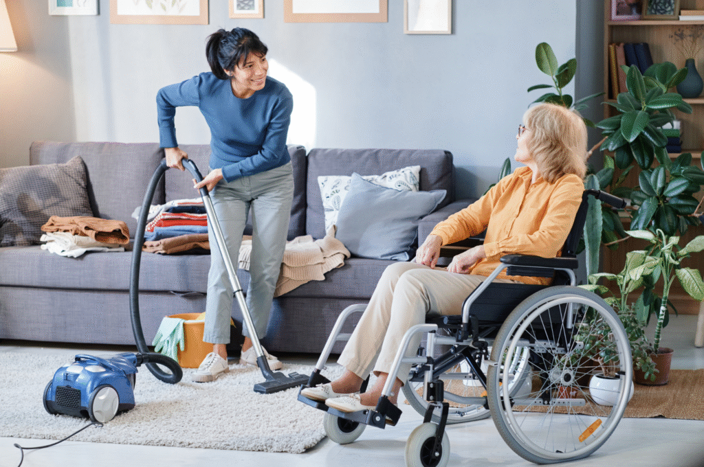 A home care worker helping a woman in wheelchair with light housekeeping job.